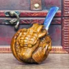 A pipe of cotinuum wood hand-carved with broken shells and young dragons